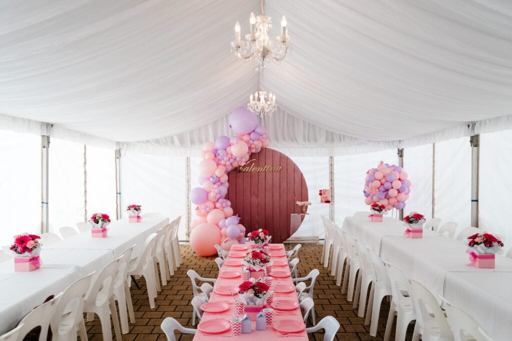 A photo of an event with a marquee setup and balloons.